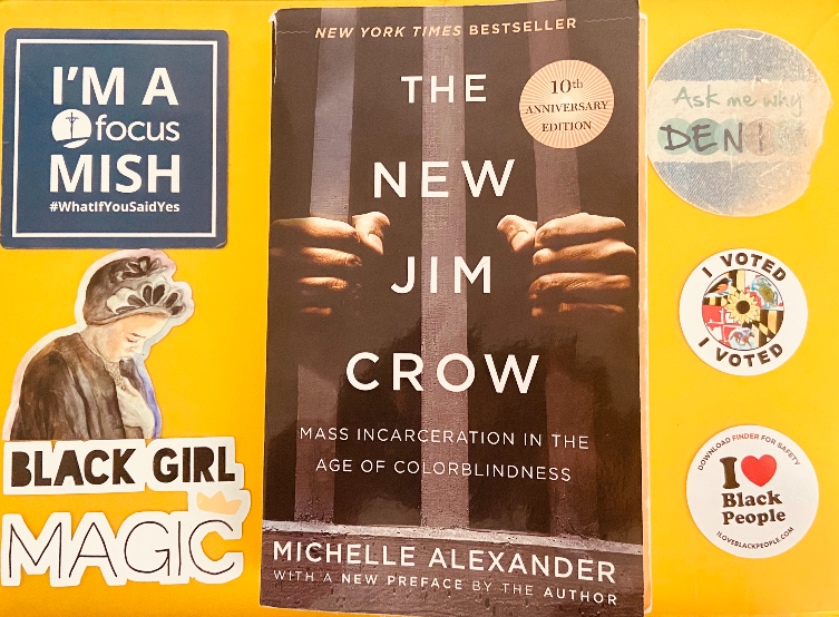 Yellow computer cover with the New Jim Crow book