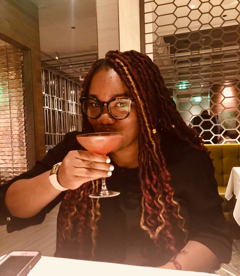 Drey sipping a cocktail in celebration of graduating from Harvard. 